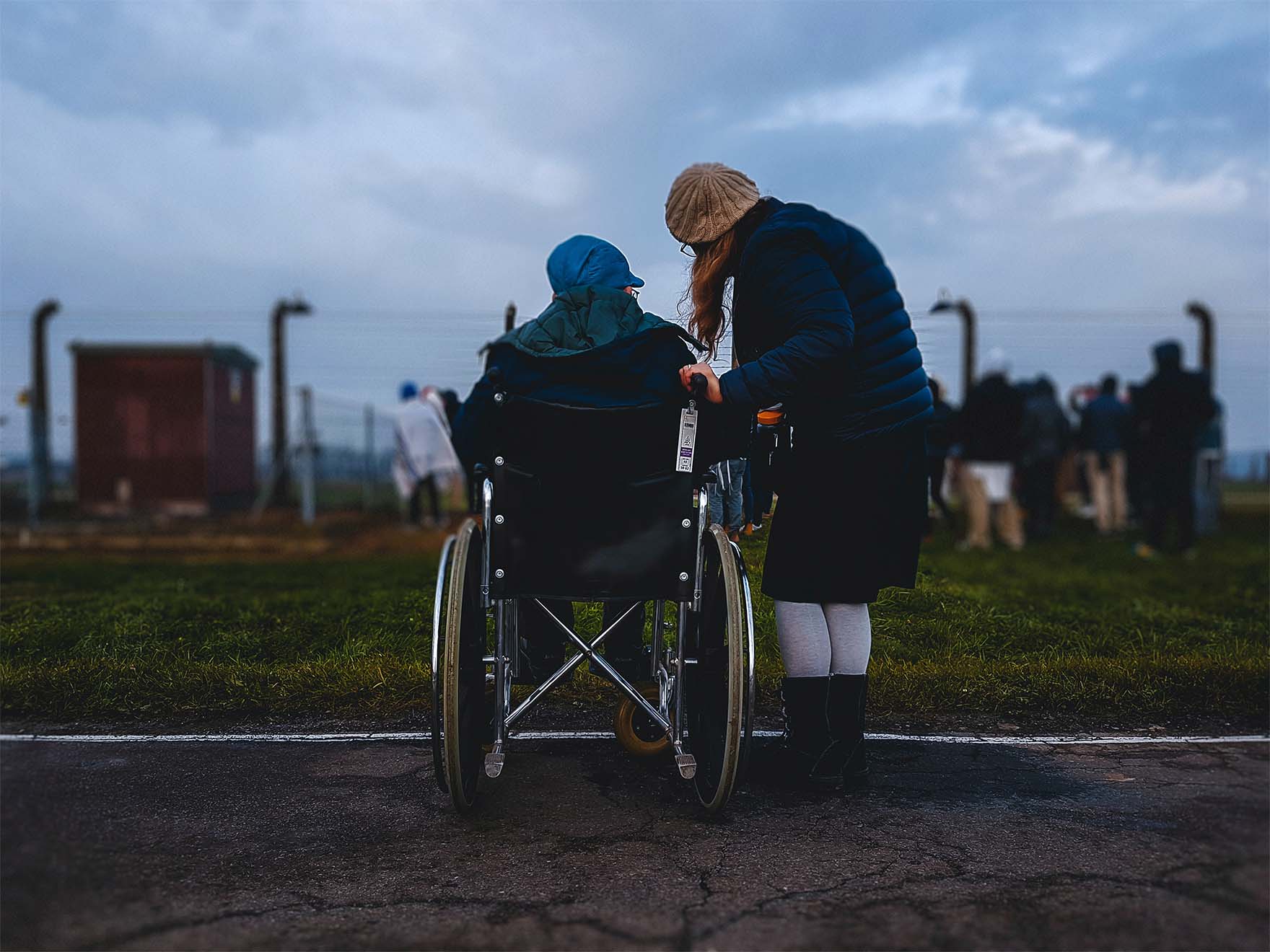 older adult sat in wheelchair and another stood next to them