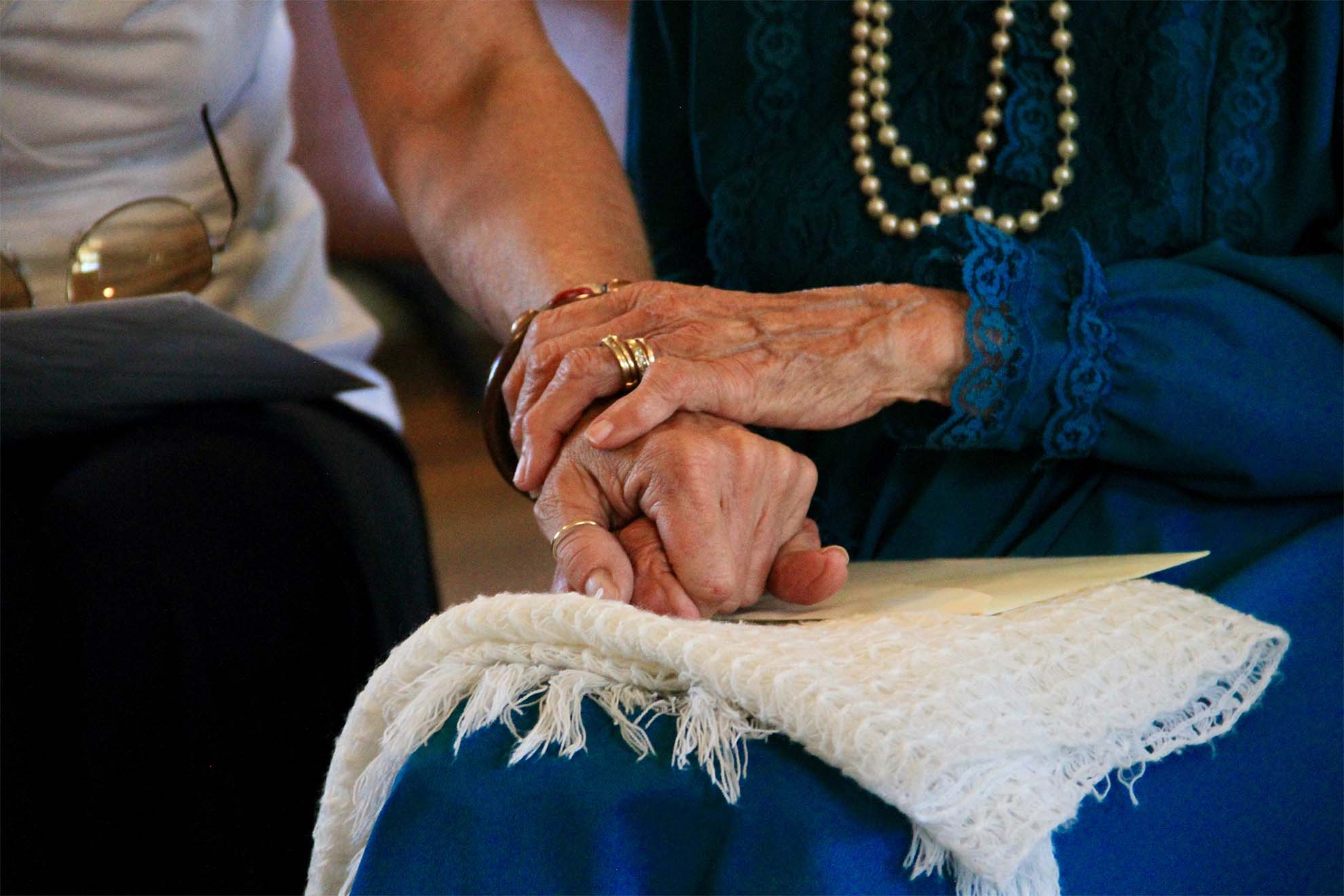 older people holding hands
